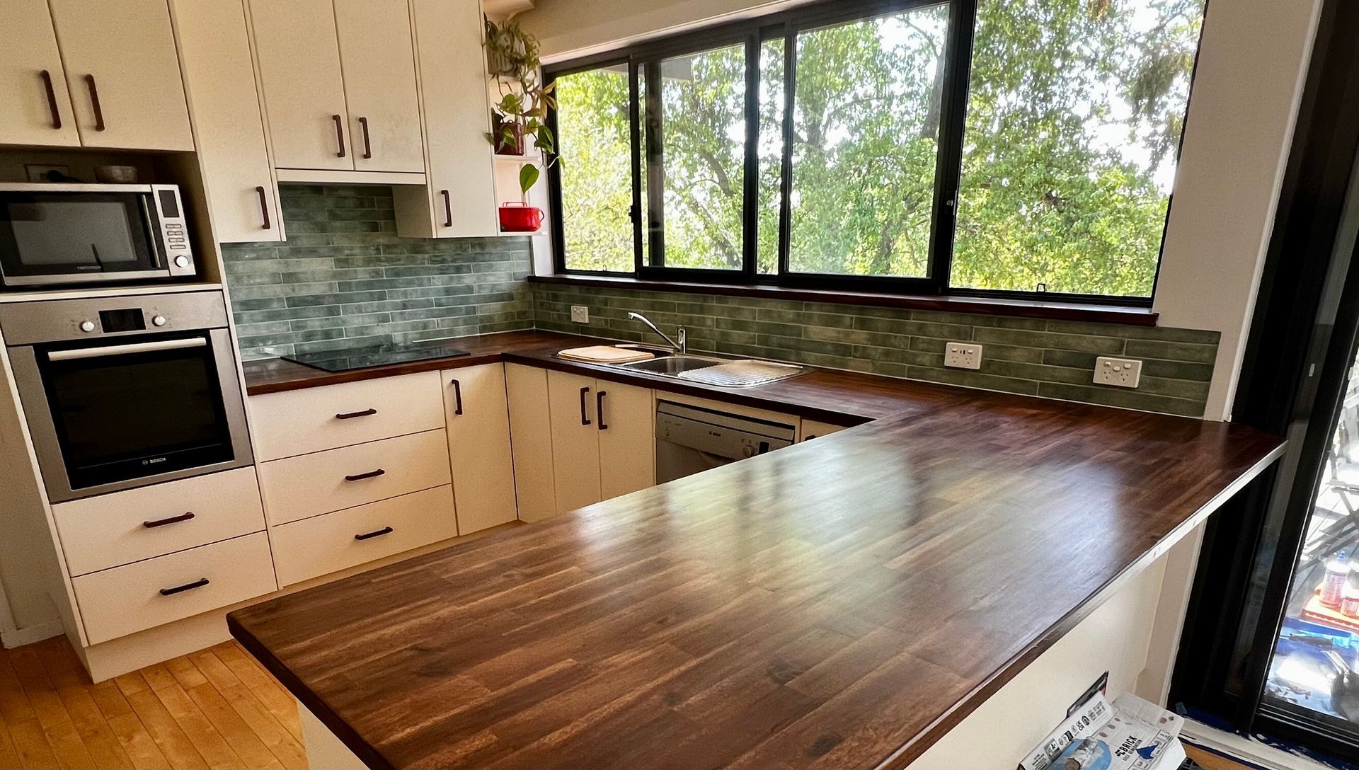 A Kitchen with White Cabinets and A Wooden Counter Top — P & M Maintenance Building Services in Yass River, NSW