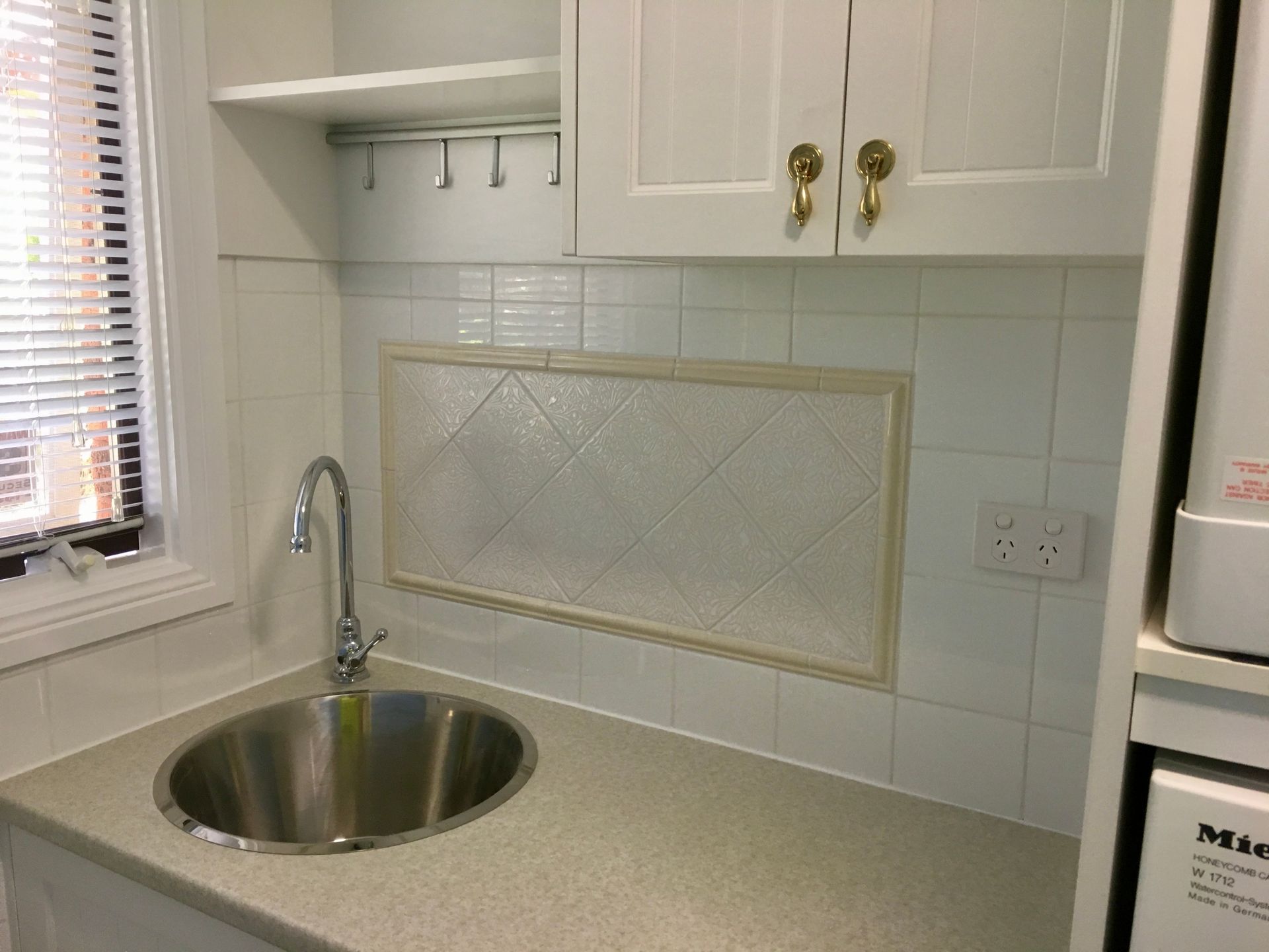 A Kitchen with A Stainless Steel Sink and A Washing Machine — P & M Maintenance Building Services in Yass River, NSW