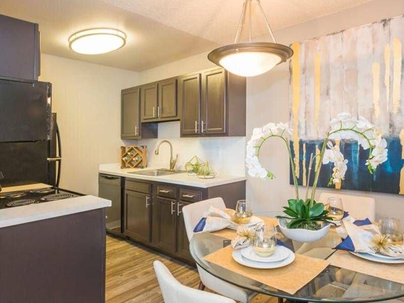 Preserve at City Center kitchen with dark cabinets, stainless appliances, and a glass dining table.