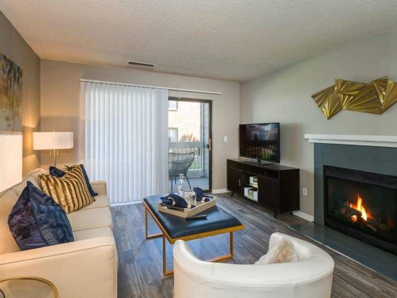 Preserve at City Center Living room in a modern apartment with sofa, coffee table, fireplace, and balcony door.