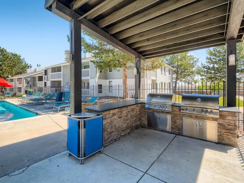 Outdoor communal BBQ grills under a shaded pavilion near the pool.