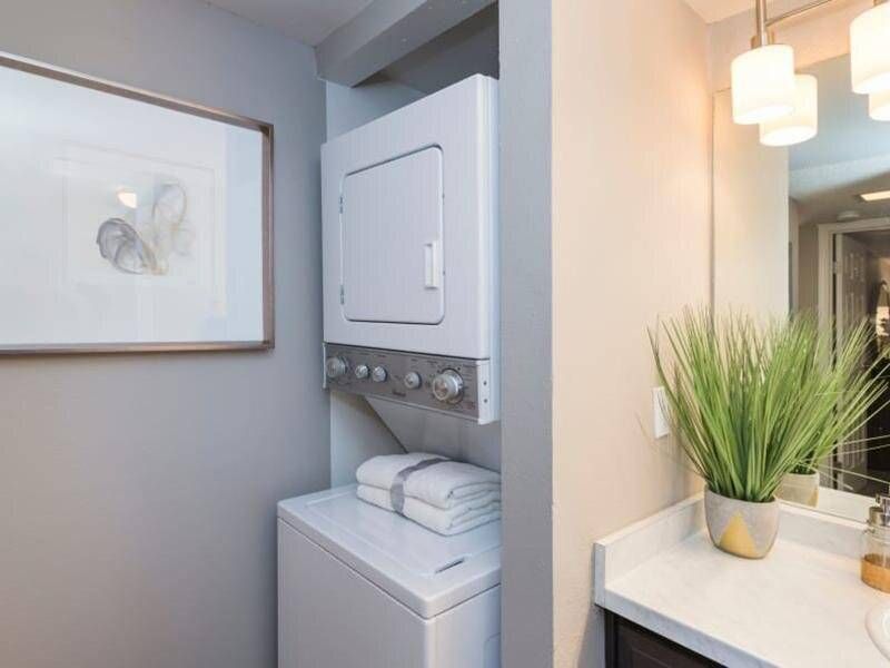 Preserve at City Center Stacked washer and dryer in a compact apartment laundry alcove.