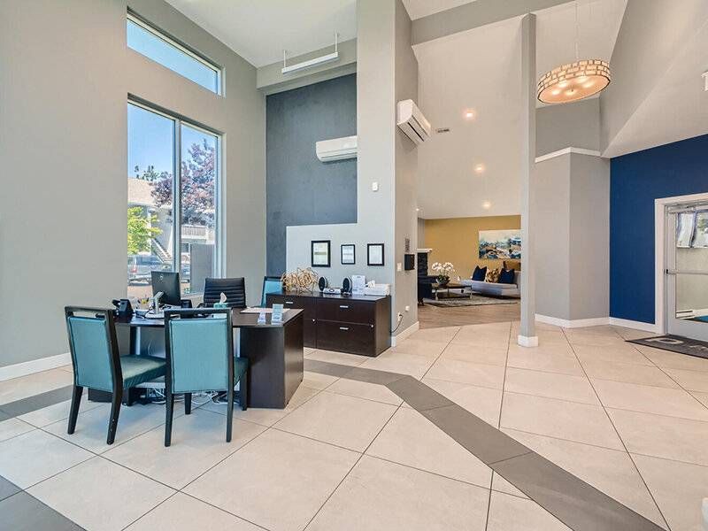 Preserve at City Center apartment lobby with reception desk, seating area, tall windows, and modern decor.
