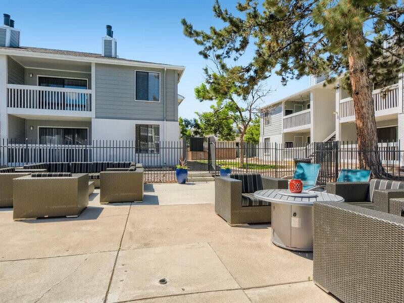 Preserve at City Center communal patio with wicker seating and a fire pit, adjacent to apartment buildings.