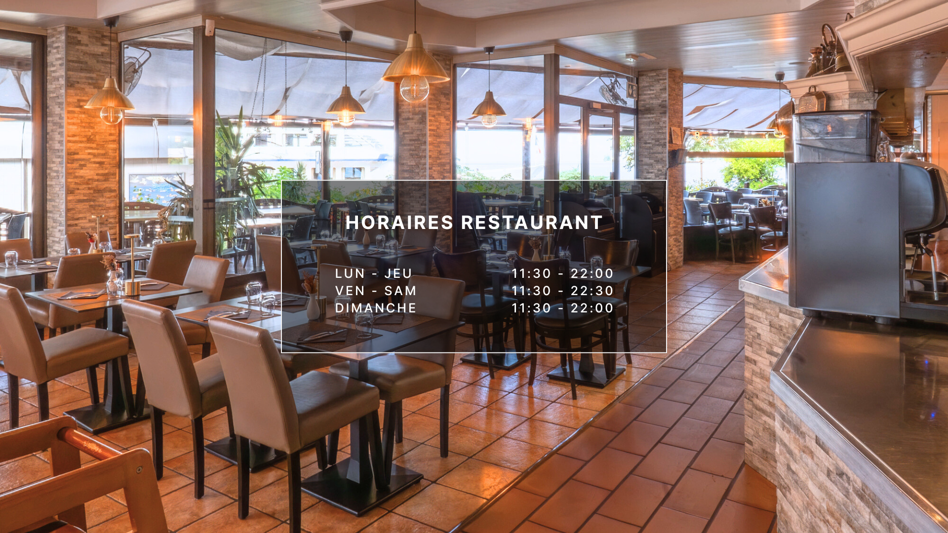 Intérieur de restaurant avec tables, chaises et heures affichées sur une vitre.