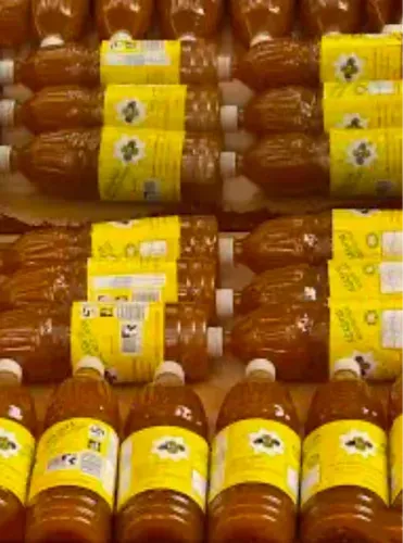 A bunch of bottles with yellow labels are lined up on a table.