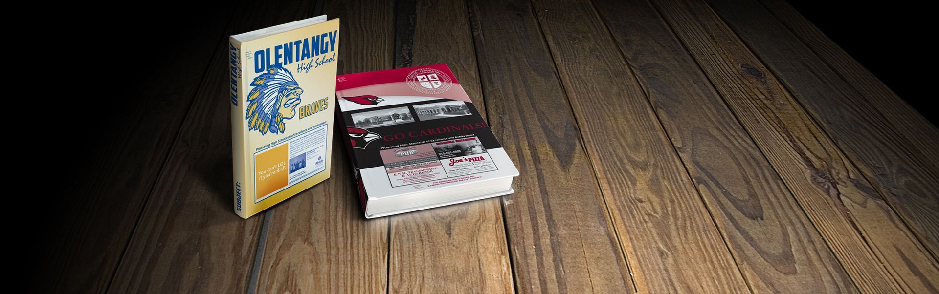 Two books on a wooden surface. One is yellow with blue text, the other is red, white, and black.