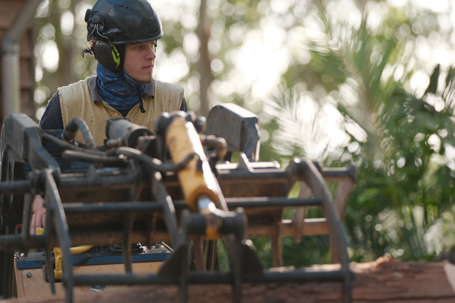 Man Operating Heavy Machinery Outdoors, Wearing Protective Gear — AAA Trees On Tweed in Byron Bay, NSW