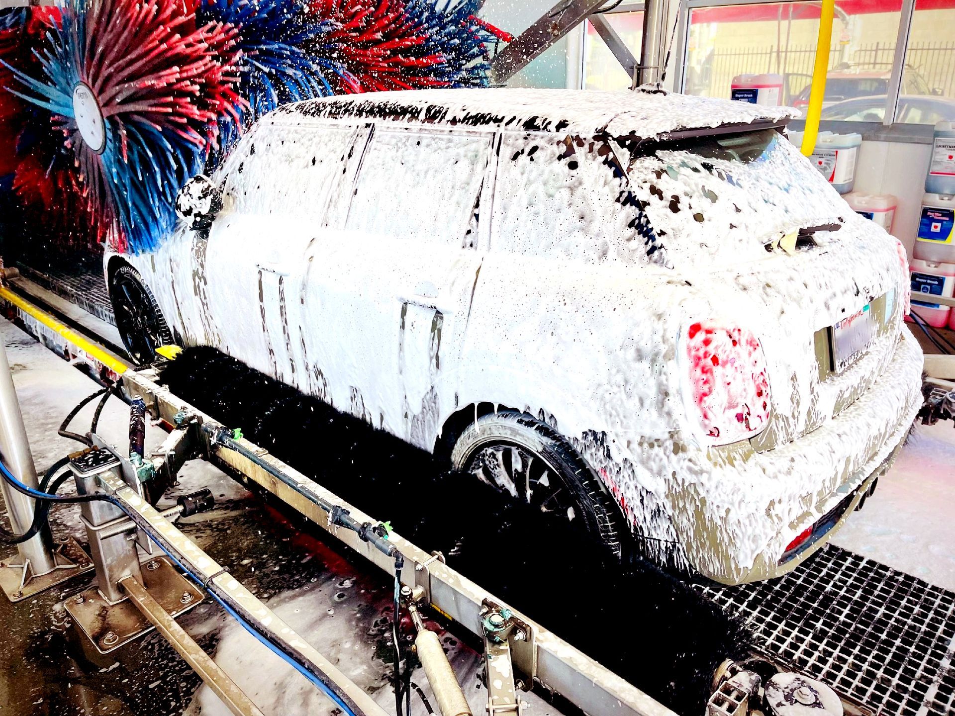 A car is covered in foam at a car wash.