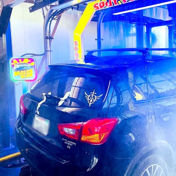 A black car is being washed in a car wash