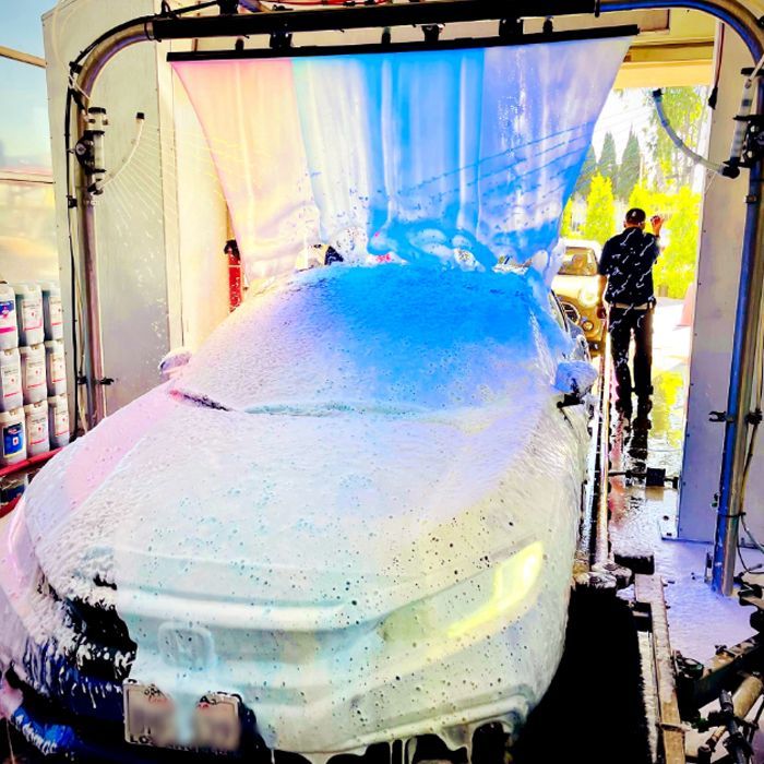 A car is covered in foam at a car wash