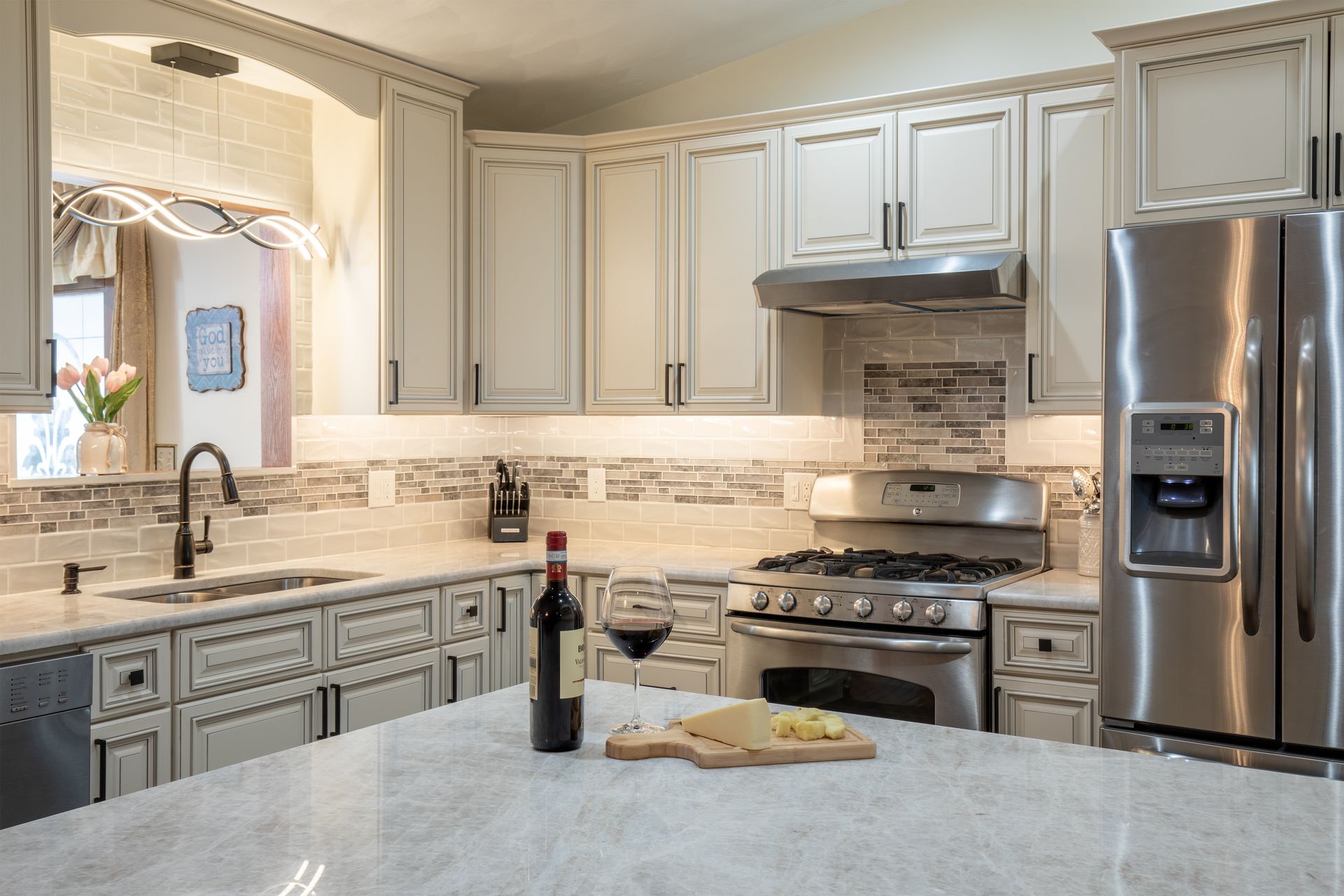 A kitchen with a bottle of wine and a glass of wine on the counter.