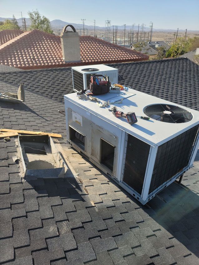 A large air conditioner is sitting on top of a roof.