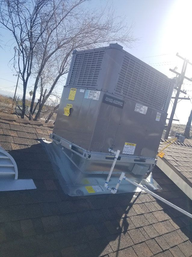 A large air conditioner is sitting on top of a roof.