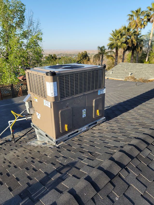 A large air conditioner is sitting on top of a roof.