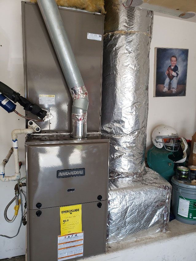 A furnace is sitting in a room next to a picture of a child.