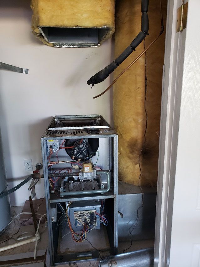 A broken air conditioner is sitting in a room next to a door.