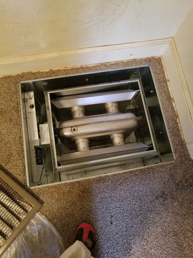 A person is standing next to a box on the floor.