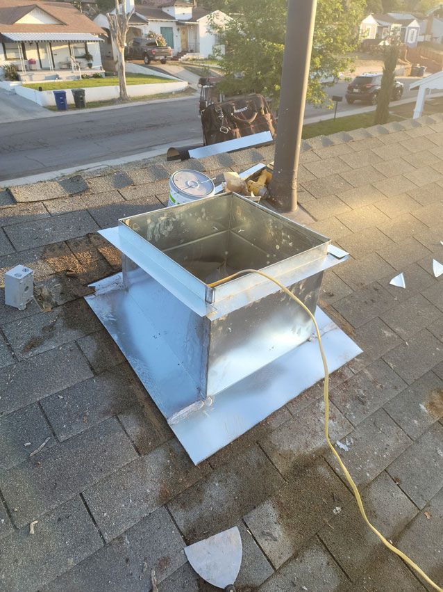 A metal box is sitting on top of a brick roof.