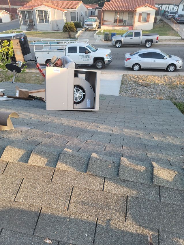 A white truck is parked on the side of the road next to a white car.