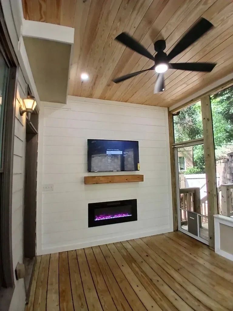 Screened porch with TV, fireplace, wood ceiling and floor.