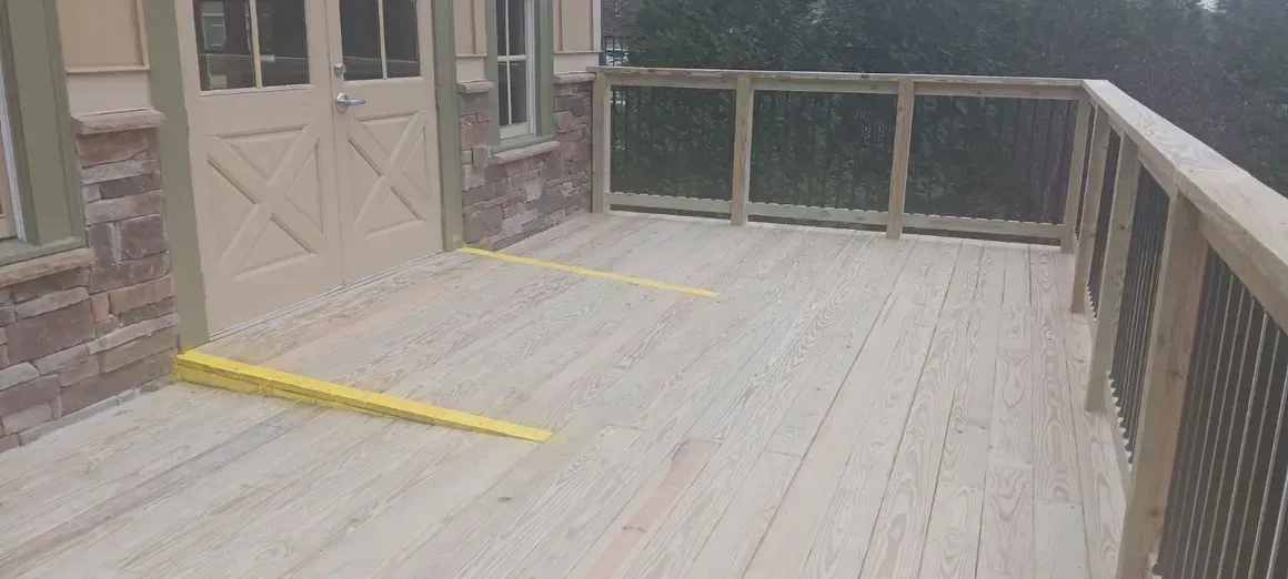 Wooden deck with railings, door, and two yellow strips.