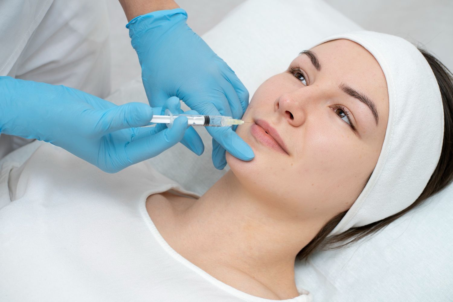 A woman is getting a botox injection in her face.