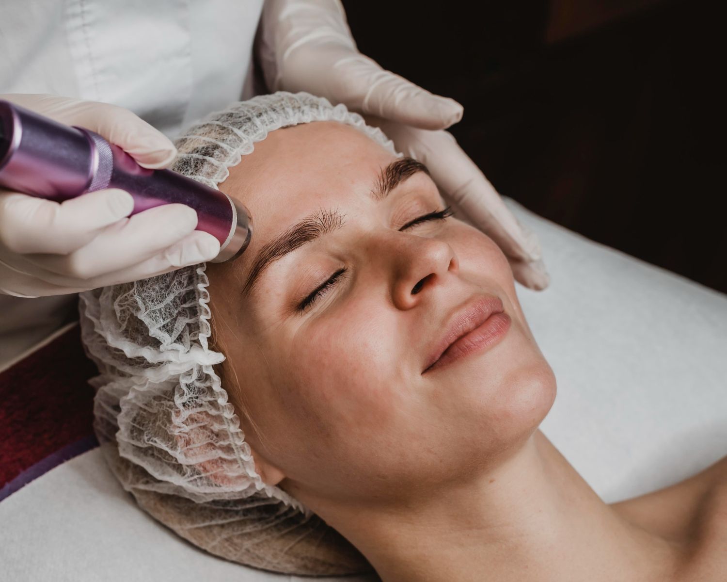 A woman is getting a facial treatment at a beauty salon.