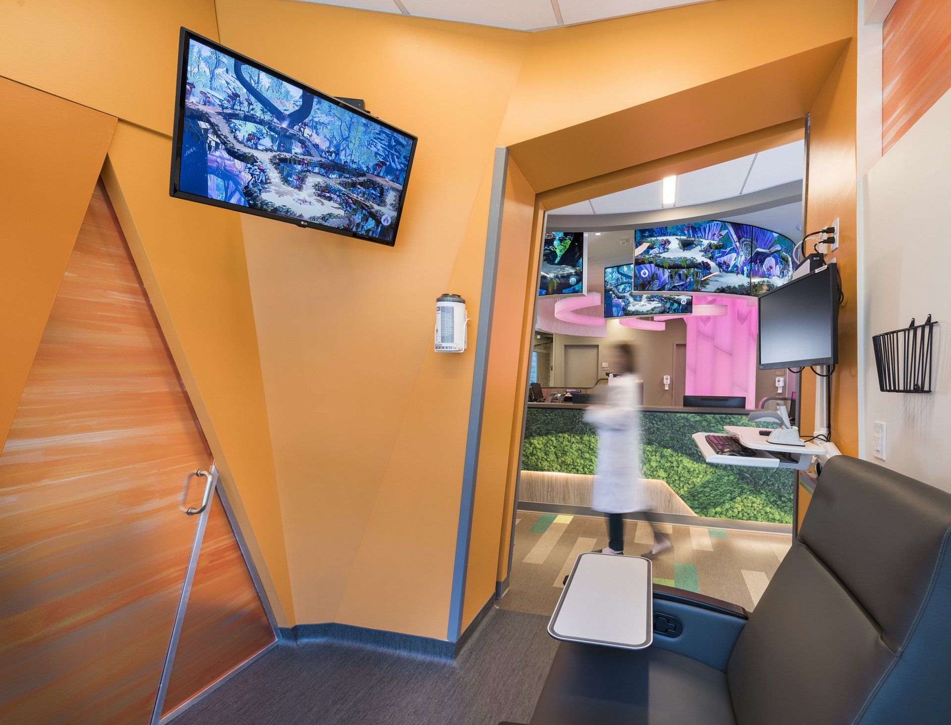 A room with a couch and a television on the wall.