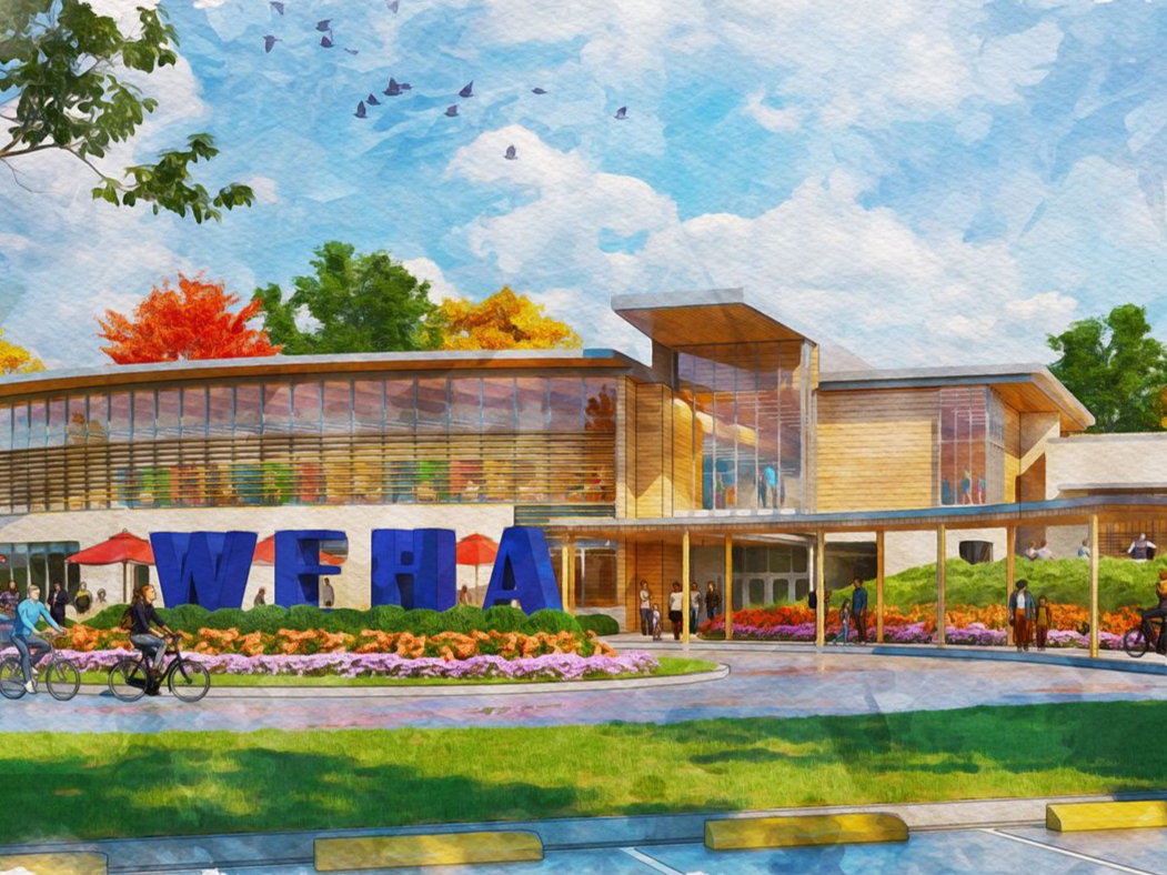 Two women are looking at a poster on an easel.