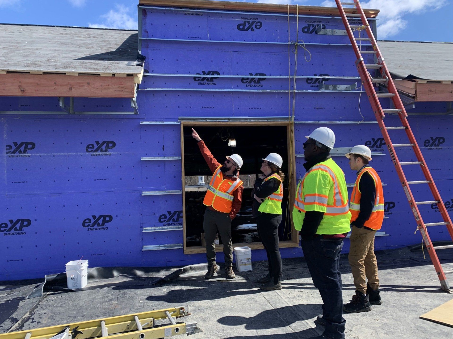 A group of construction workers are standing in front of a building under construction.
