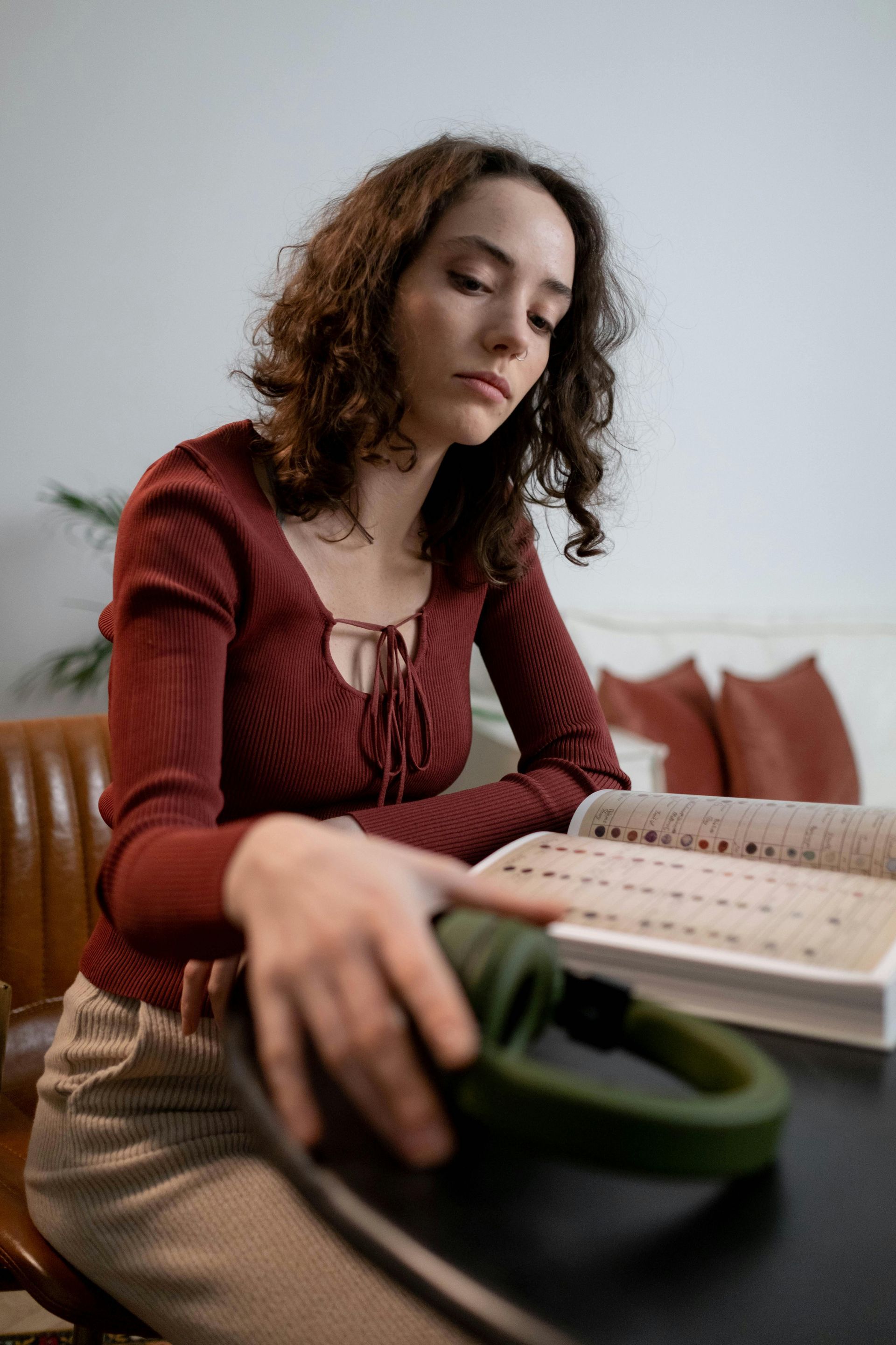 A woman is sitting at a table reading a book.