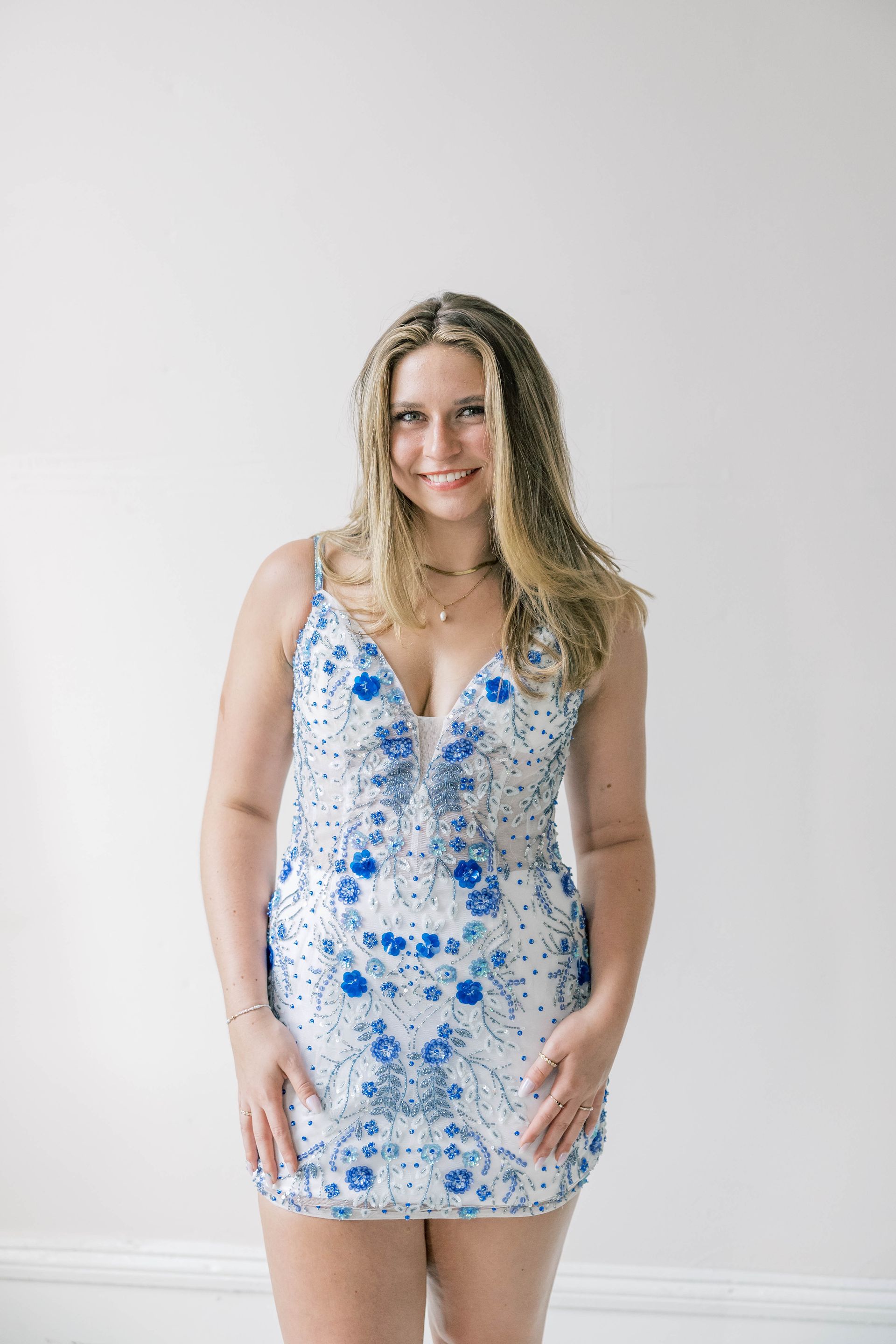 Three women are standing next to each other in red and blue dresses.