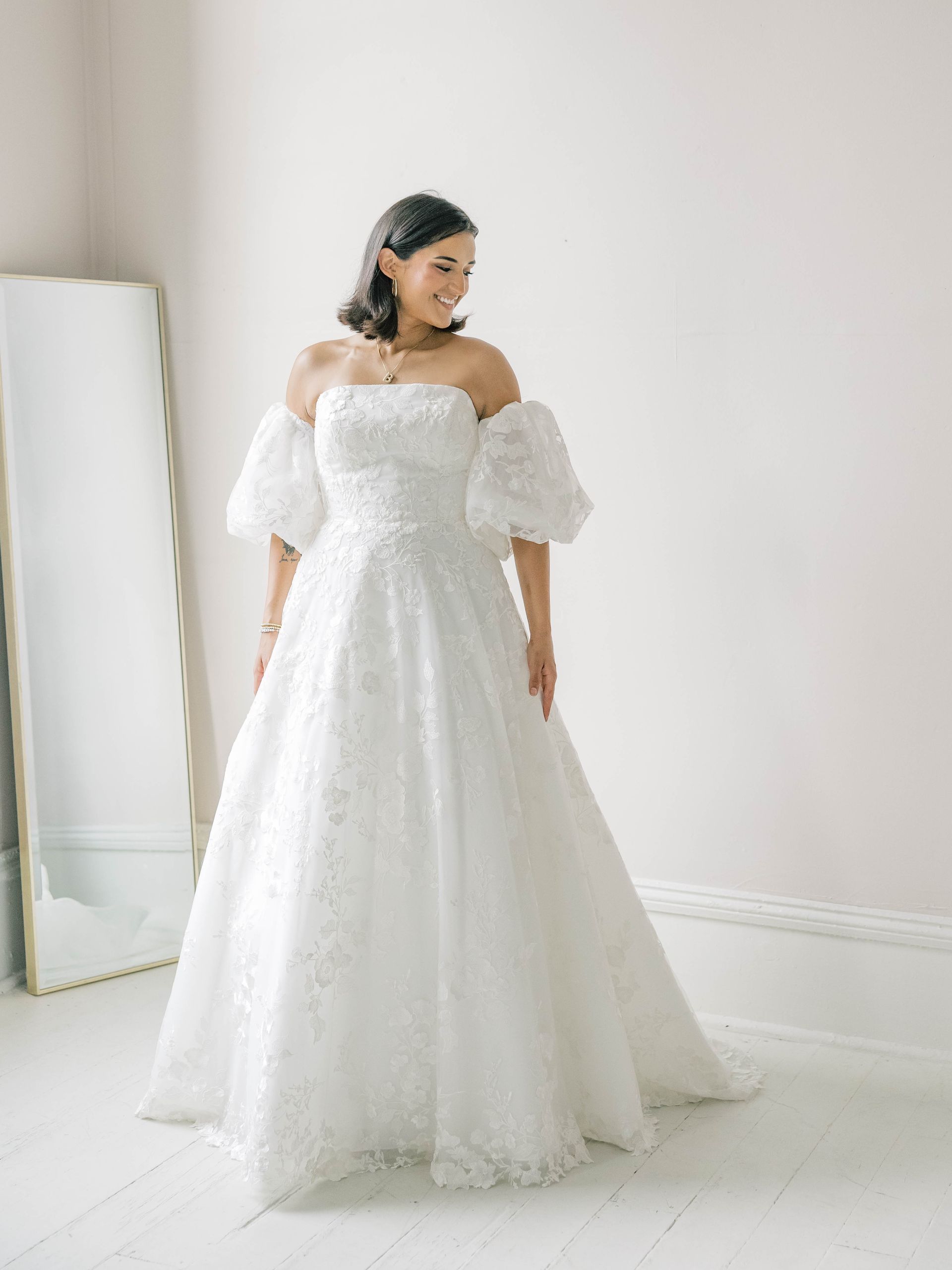 A woman is wearing a white wedding dress with a high slit.
