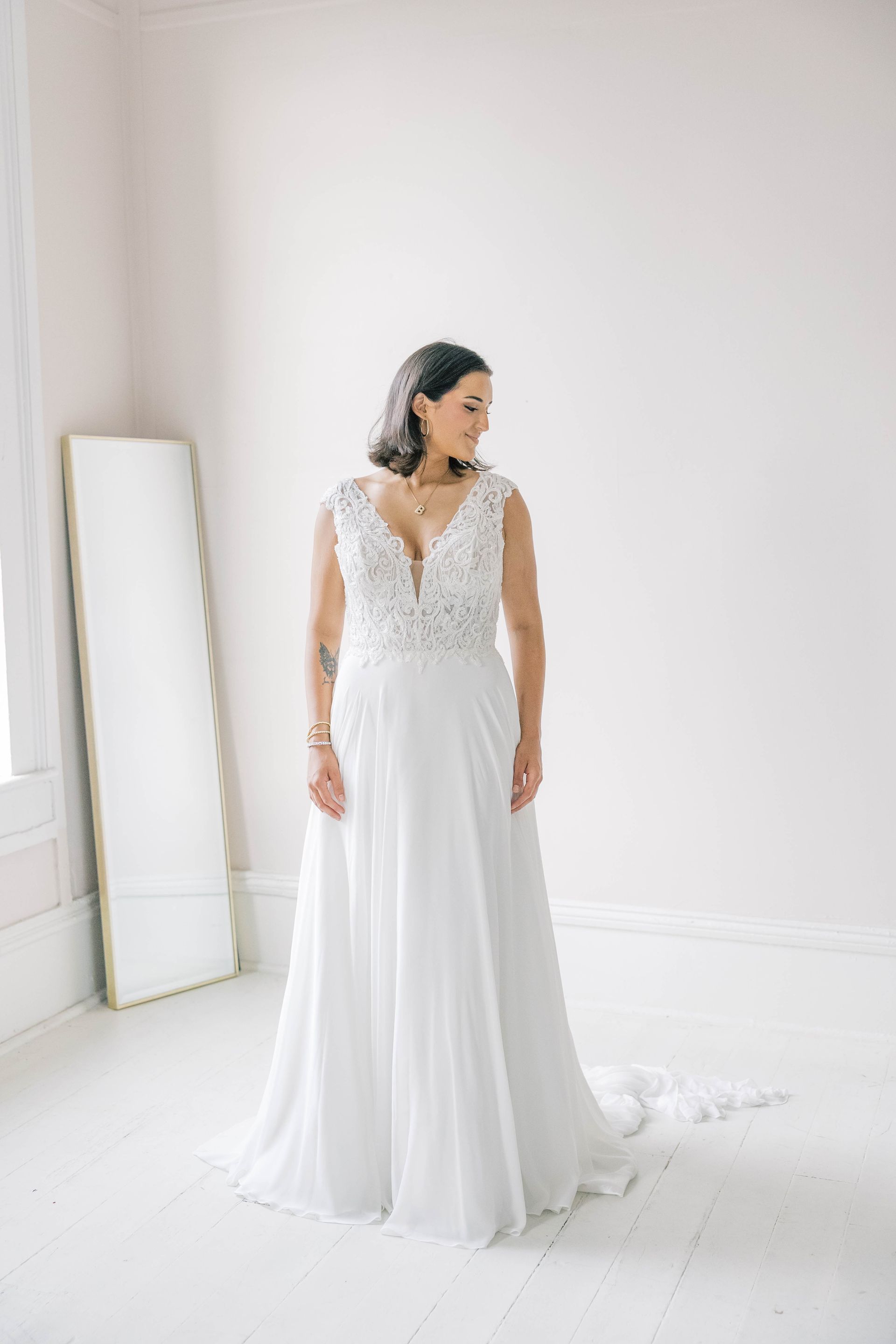 A woman is trying on a wedding dress in a bridal shop.