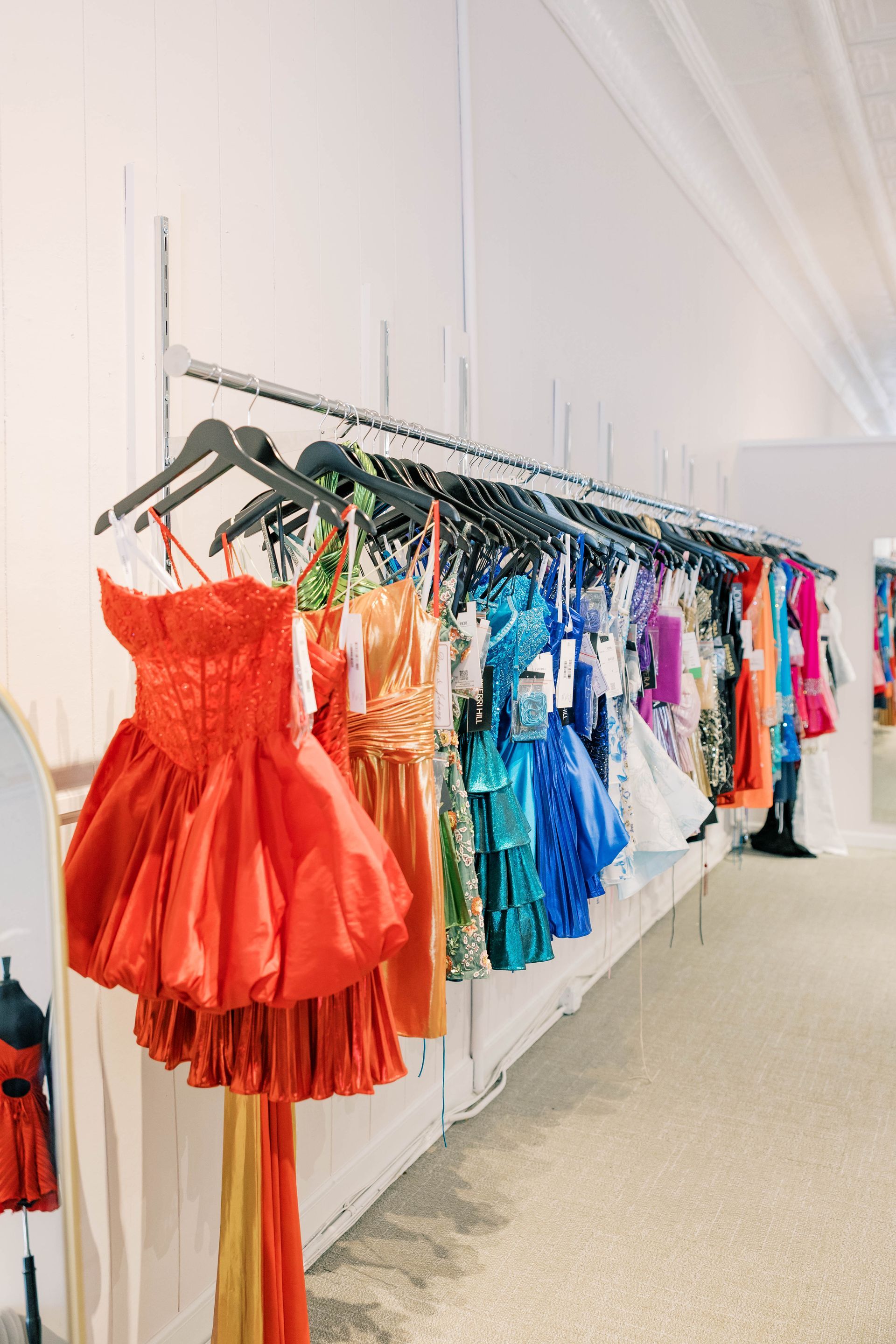 A woman in a wedding dress is standing in a room next to a couch.