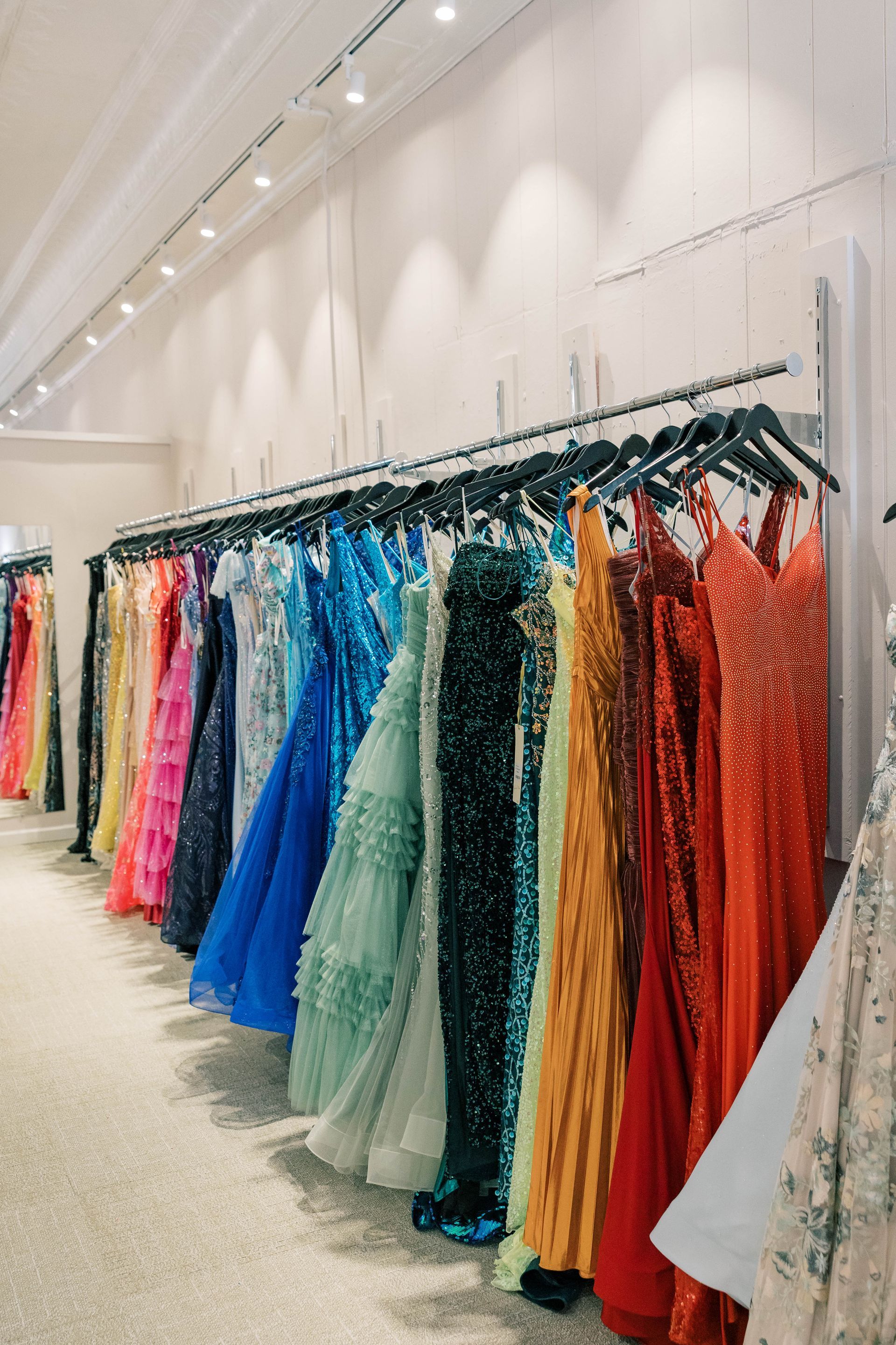 A woman in a blue dress is standing in a room next to a couch.