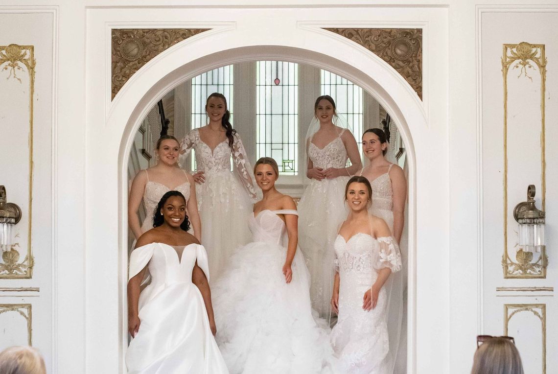 A group of women in wedding dresses are posing for a picture.