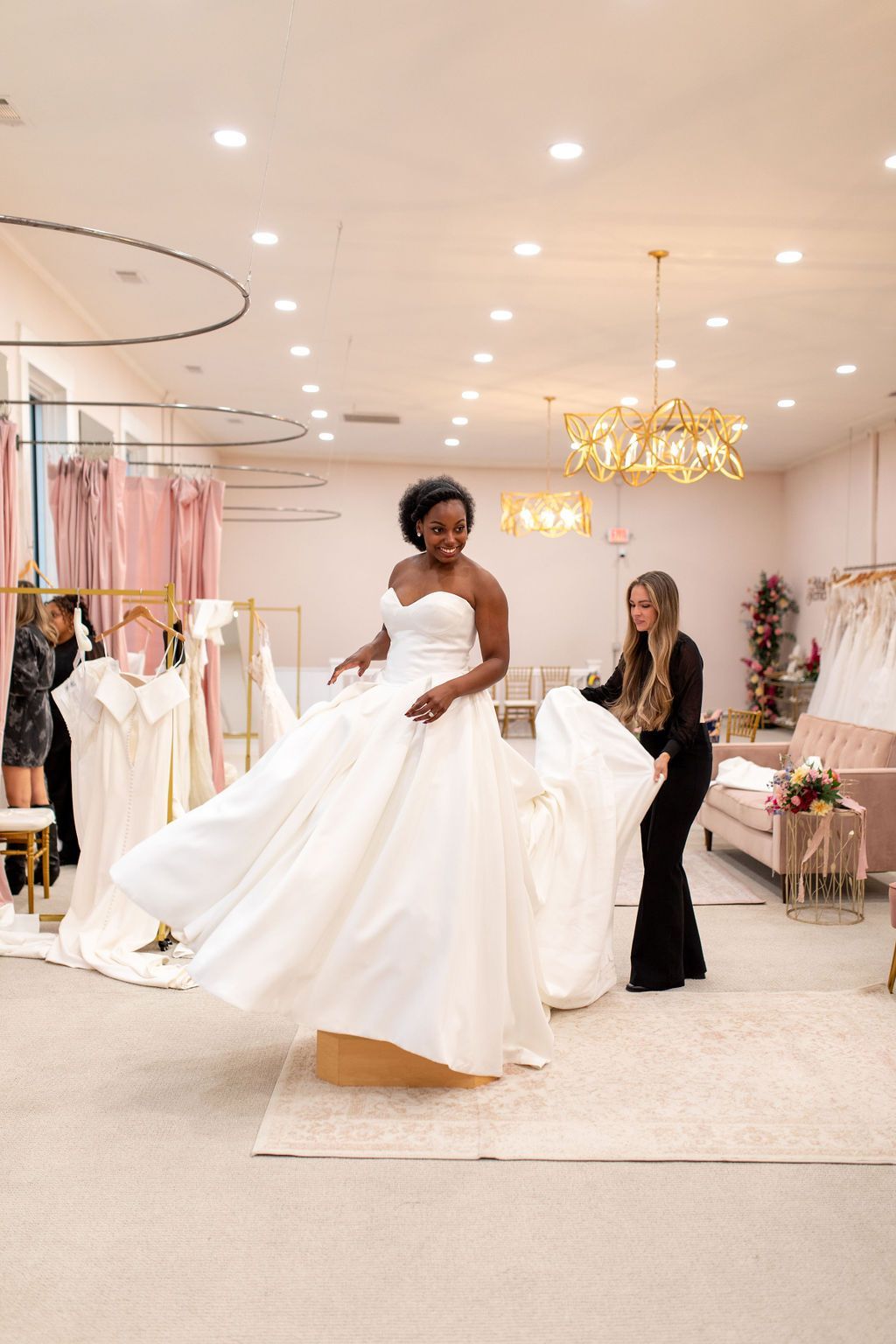 A woman is trying on a wedding dress in a bridal shop.