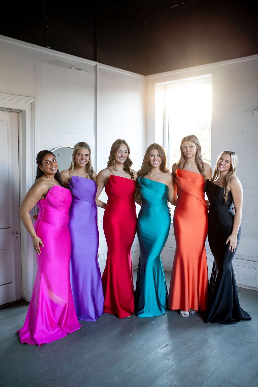 A group of women in colorful dresses are posing for a picture.