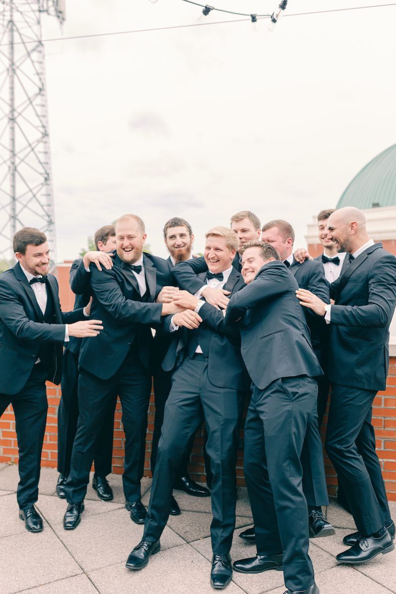 A group of men in suits and bow ties are posing for a picture.