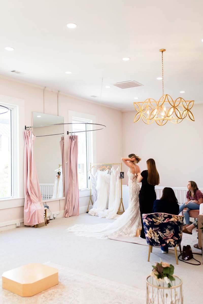 A woman is trying on a wedding dress in a bridal shop.