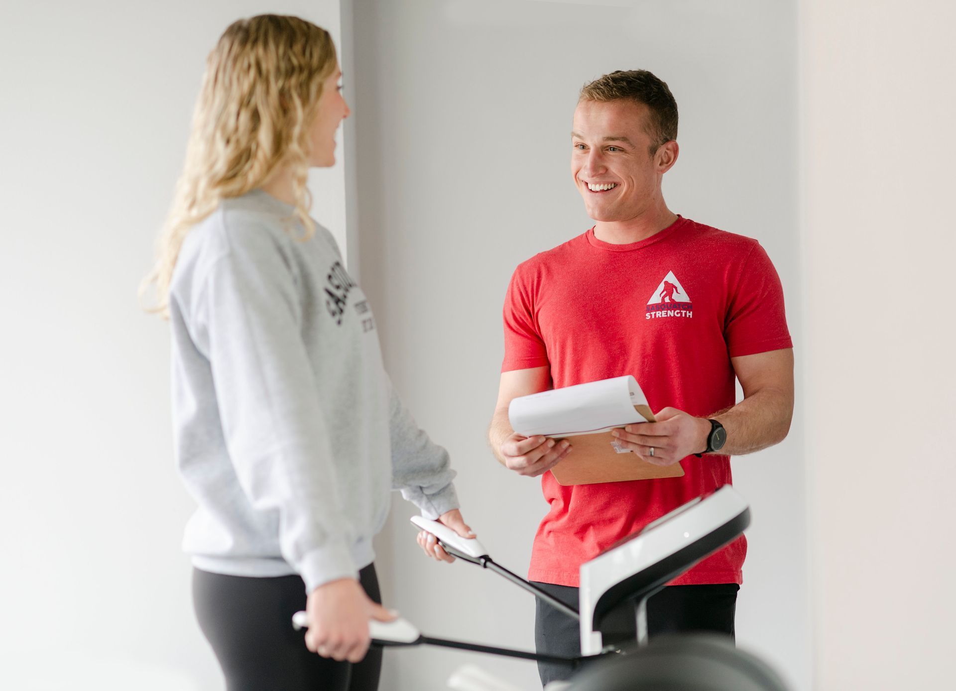 A man and a woman are standing next to each other in a gym.