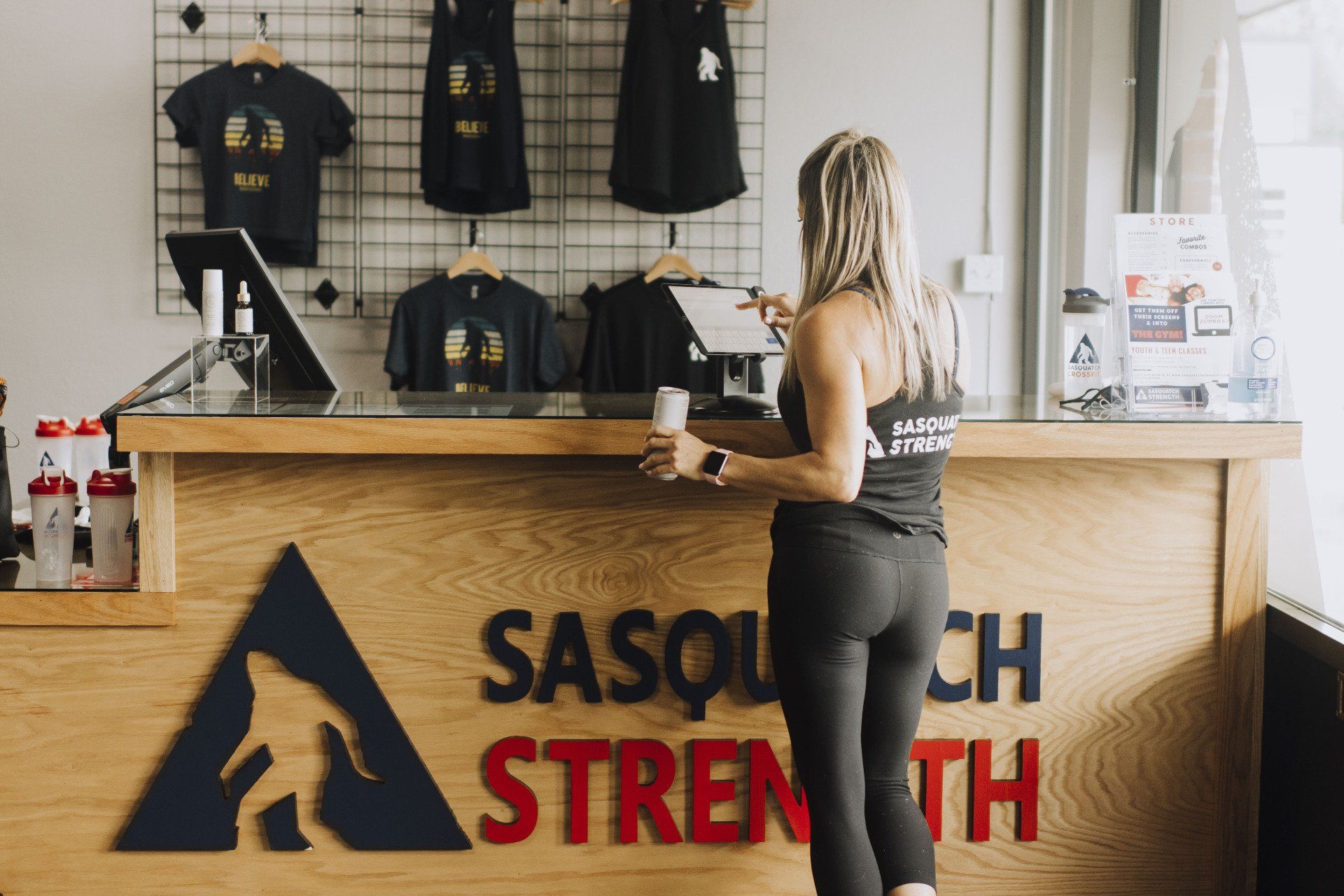 A woman is standing at a counter in a gym.
