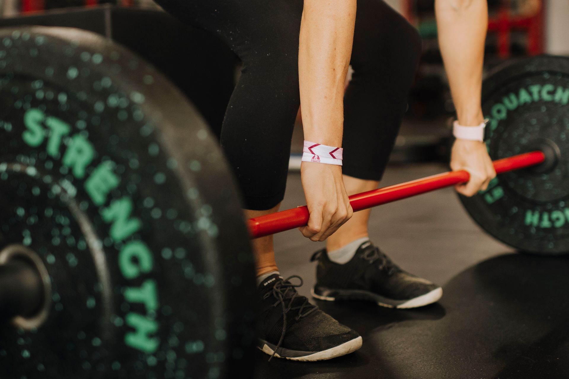 A person is lifting a barbell in a gym.
