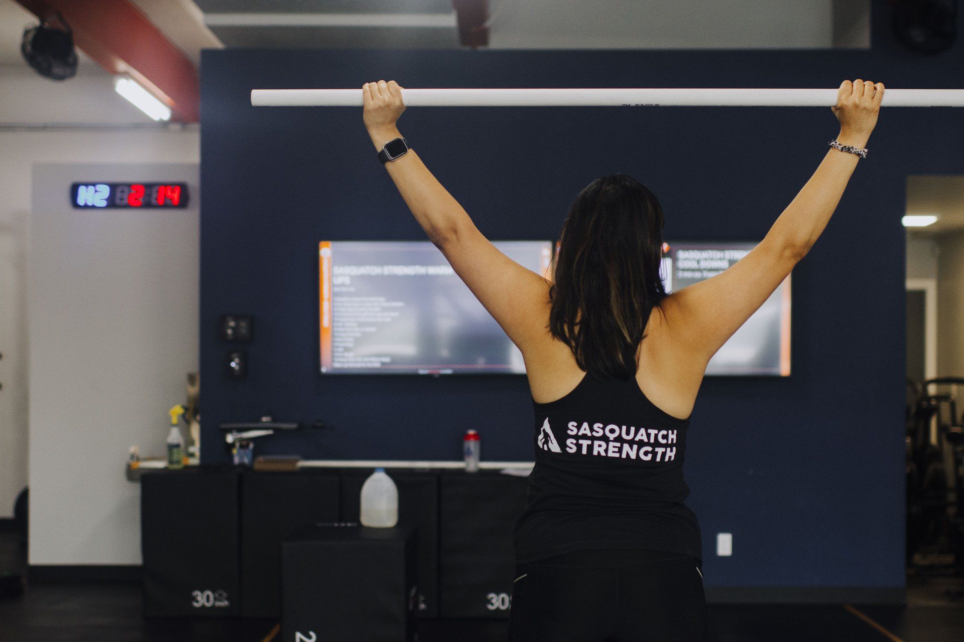 A woman is doing a pull up in a gym.