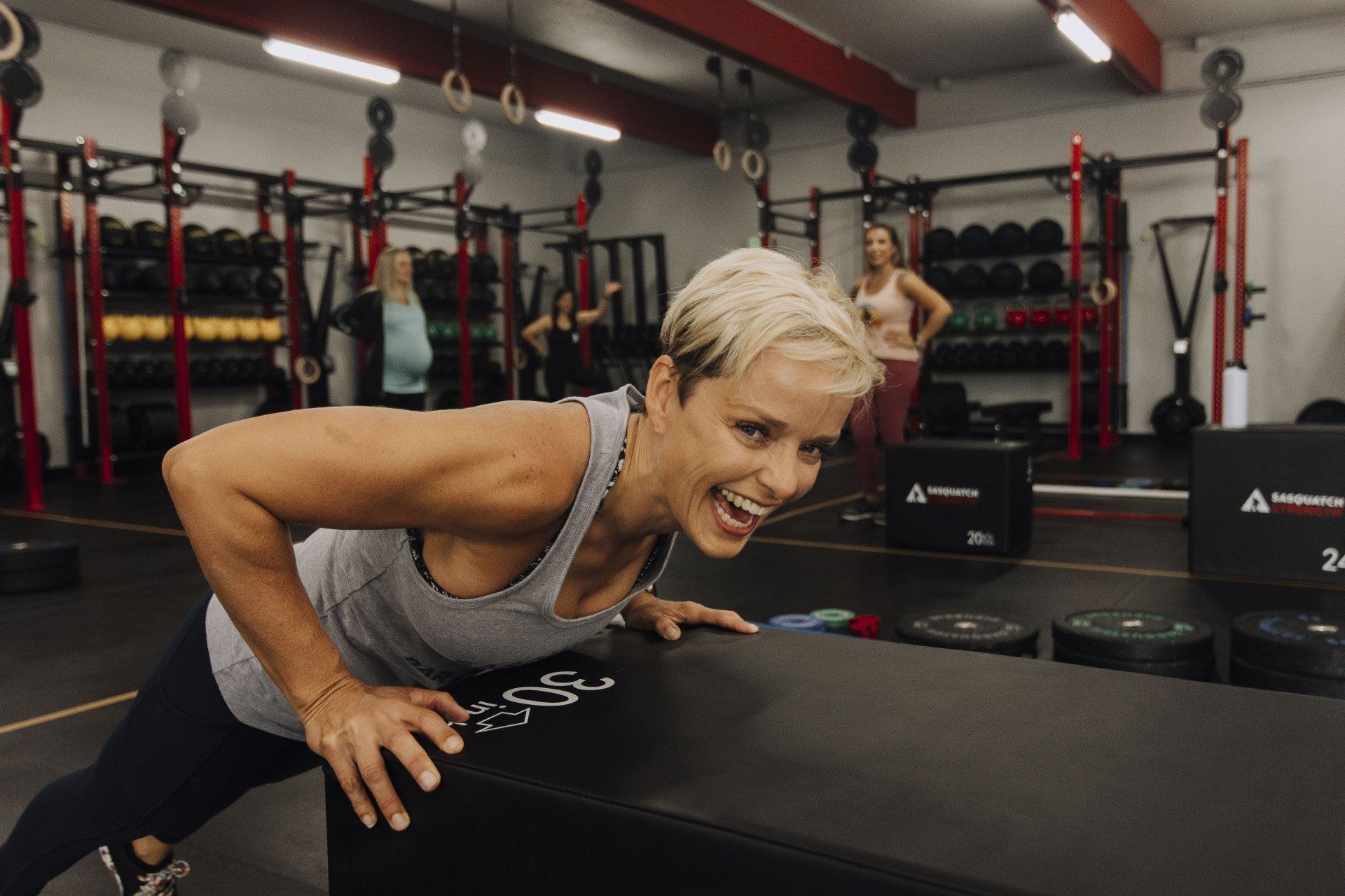 A woman is doing push ups in a gym.