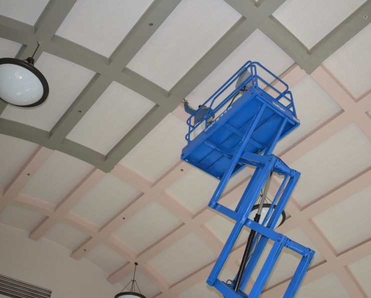 Worker Painting the Ceiling of a Building — Lubbock, TX — DM Painting