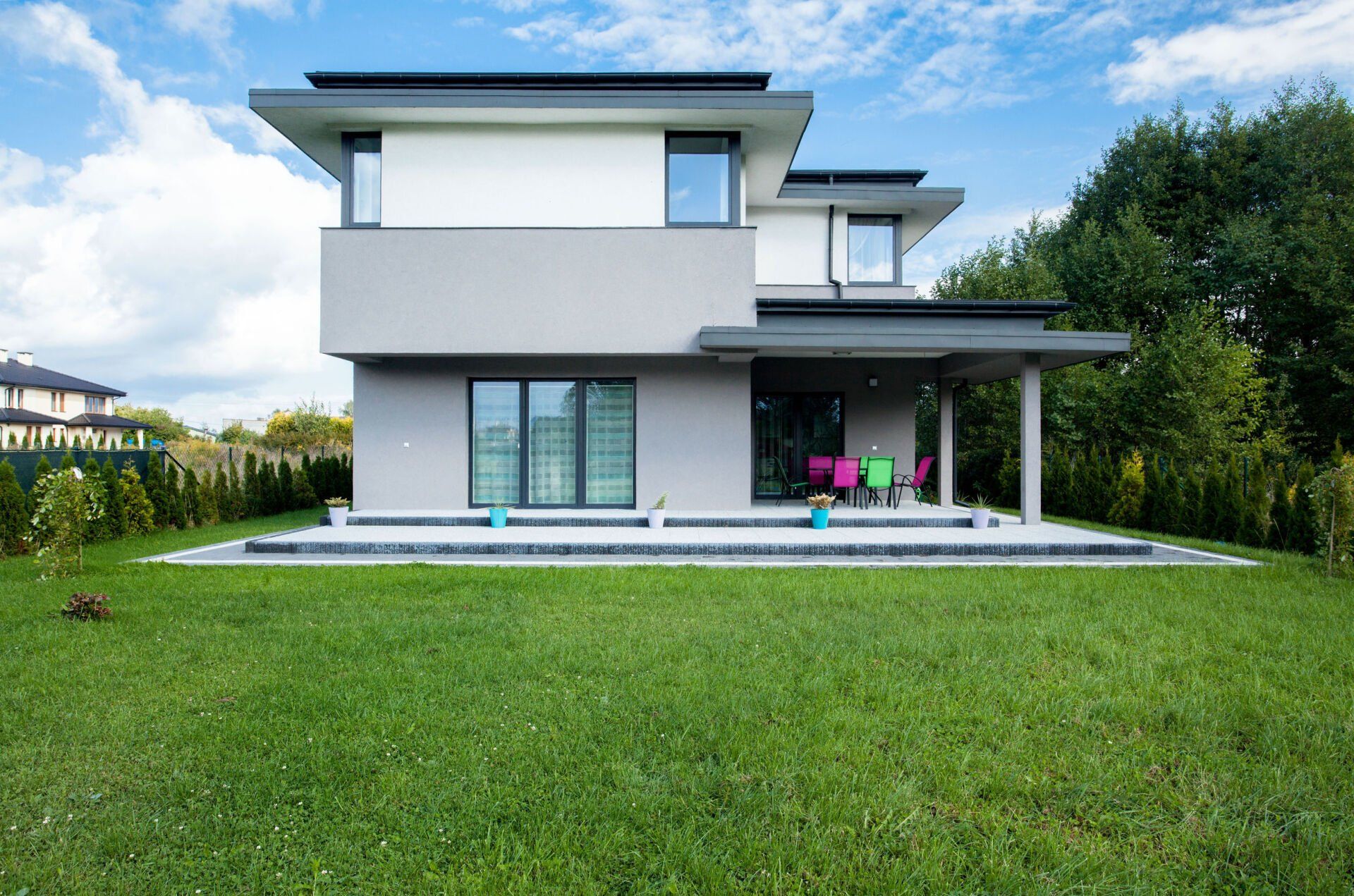 A modern house with a large lawn in front of it.