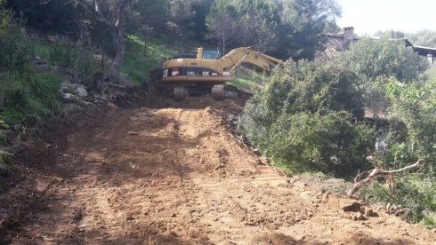 macchina di movimento terra mentre spiana un sentiero